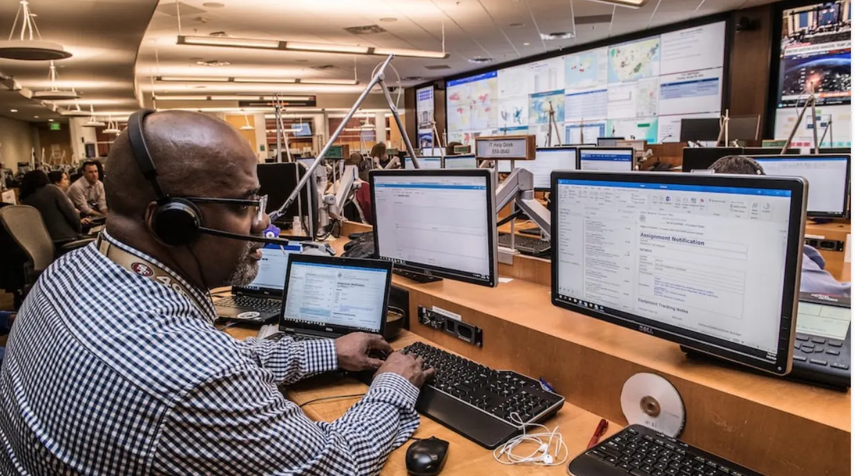 Control-room operator wearing a headset in front of monitoring screens